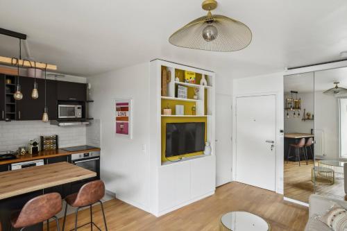 une cuisine et un salon avec une table et des chaises dans l'établissement Le Petit Bijou de Suresnes, à Suresnes