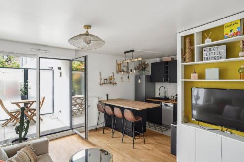 Il dispose d'une cuisine et d'un salon avec une table et une télévision. dans l'établissement Le Petit Bijou de Suresnes, à Suresnes