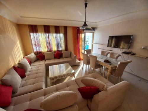 a living room with a couch and a table at Appartement de luxe au coeur de la marina Hammamet in Hammamet