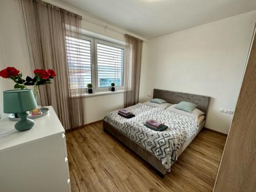 a small bedroom with a bed and a window at Tower Apartments Centrum in Spišská Nová Ves