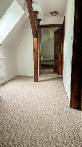 an attic room with a hallway with a bed in it at Chalupa Amálka in Maršov nad Metují