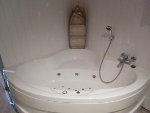 a white bath tub with a shower in a bathroom at Ferienhaus Büffel mit Sauna in Twist in Twist
