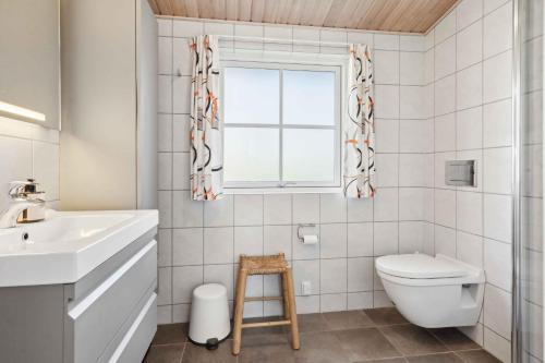 baño con lavabo y aseo y ventana en Lovely Cottage Within Walking Distance To The Sea, en Brenderup