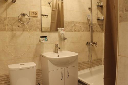 a bathroom with a toilet and a sink and a shower at Salamat Hotel in Bishkek