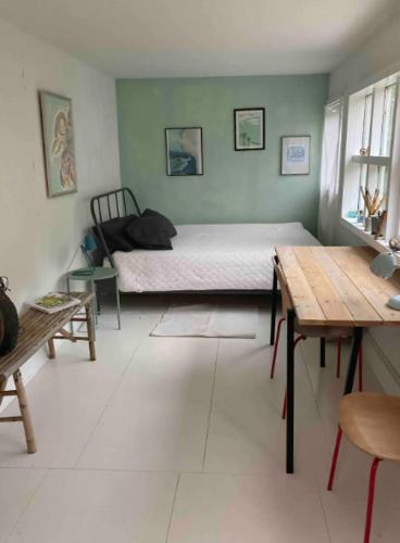 ein Schlafzimmer mit einem Bett und einem Tisch darin in der Unterkunft Lovely Summer House By The Coast, in Præstø