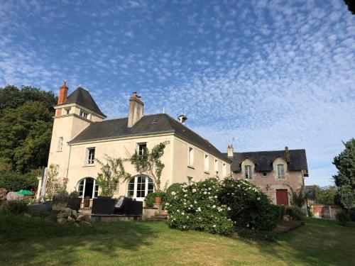 Une grande maison blanche avec une tour en haut dans l'établissement Magnifique maison de maître saumuroise, à Saumur