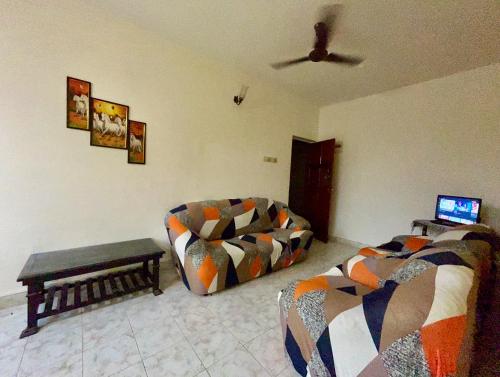 a living room with a couch and a table at Muffys Pool Apartment in Goa
