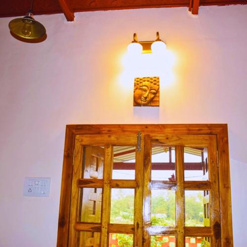 a room with a door and a light and a window at Karjat Hills - Refreshing Farmstay in Karjat