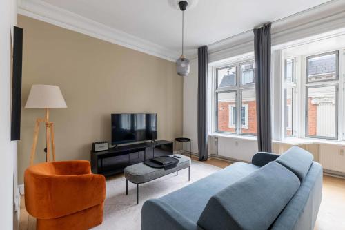 a living room with a blue couch and a tv at Apartment with Private Balcony in central Copenhagen City in Copenhagen