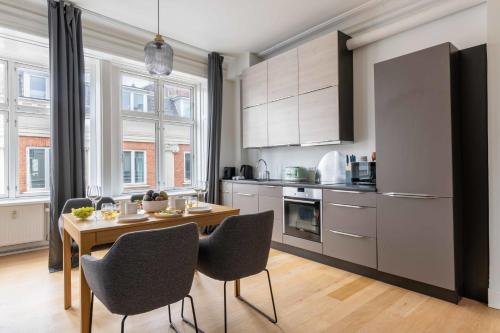 a kitchen with a table and chairs in a room at Apartment with Private Balcony in central Copenhagen City in Copenhagen