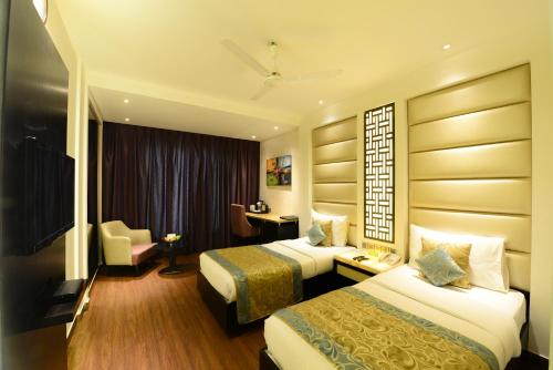 una camera d'albergo con due letti e una sedia di Hotel City Star a Nuova Delhi