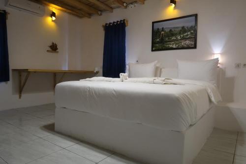 Un dormitorio con una cama blanca con un osito de peluche. en Blue Planet Dive Resort en Bira