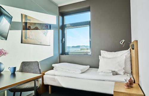 斯塔萬格的住宿－佛勒斯時尚酒店，客房设有床、书桌和窗户。
