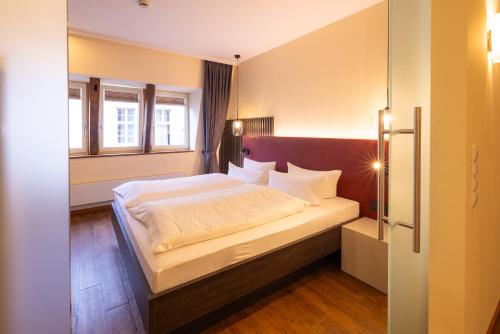 a bedroom with a large bed with white sheets and pillows at Altstadthof Freinsheim in Freinsheim