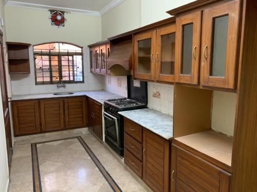 a kitchen with wooden cabinets and a stove at Every lodge guesthouse in Islamabad