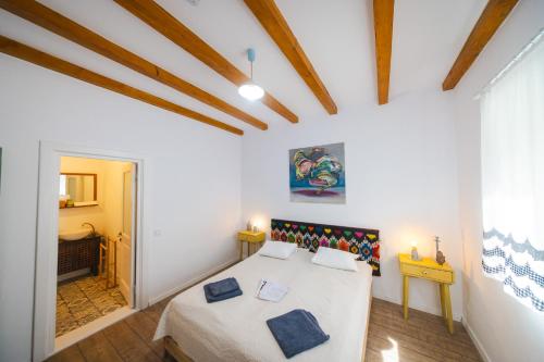a bedroom with a bed in a room with wooden ceilings at CASA LILA in Colţi