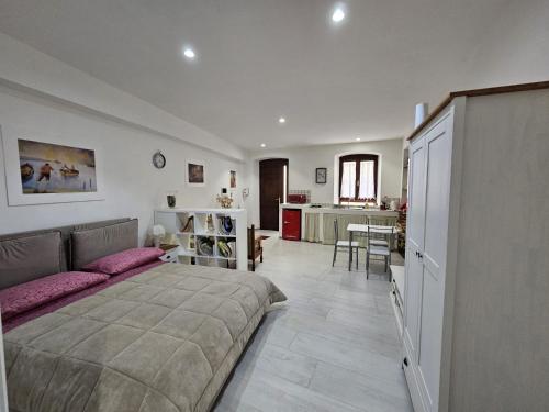 Un dormitorio con una cama grande y una cocina. en Casa Pisani 19, en Iglesias