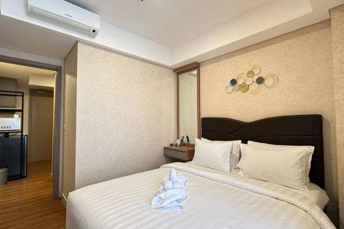 a bedroom with a large bed with white sheets at goldcoast studio europe sofabed wifi netflix in Jakarta
