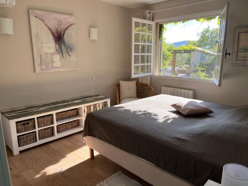um quarto com uma cama grande e uma janela em Les Mille Mimosas em Les Assions