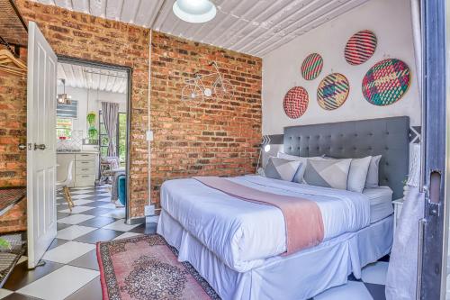 a bedroom with a bed and a brick wall at The Bedford Manor in Centurion