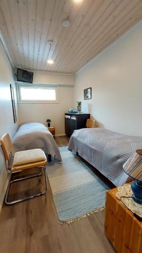 a bedroom with two beds and a table and a window at JM Rally Parc Ferme Rallimuseo in Tuuri