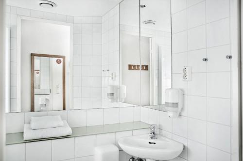 a white bathroom with a sink and a mirror at Smarthotel Forus in Stavanger