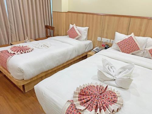 a hotel room with two beds with flowers on them at Hotel Lumbini Airport in Kathmandu