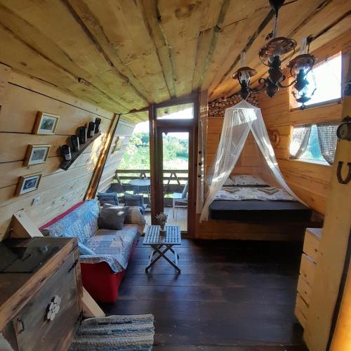 a room with a bed and a couch in a cabin at Glamping pod Hrastom in Dramlje