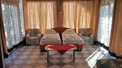 a hospital room with two beds and two chairs at Novákporta vendégház in Lakhegy