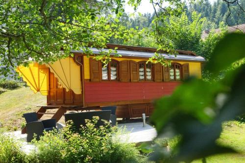 a yellow and red train car on display in a yard at Hôtel Restaurant des Lacs in Chaux-des-Crotenay