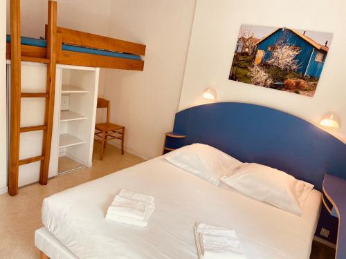 een slaapkamer met een bed en een stapelbed bij Arc en Ciel Oléron in Saint-Trojan-les-Bains