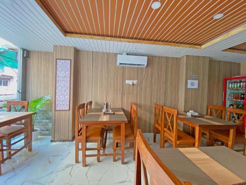 a dining room with wooden tables and chairs at Hotel Lumbini Airport in Kathmandu