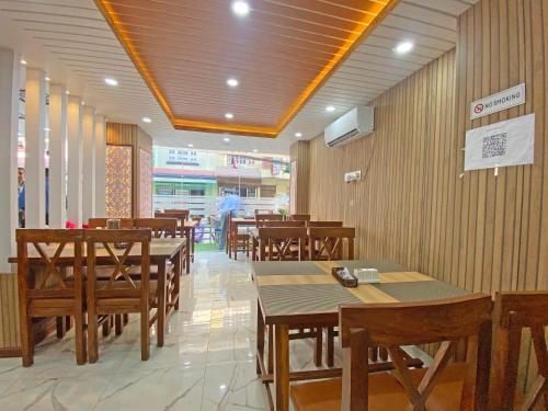 a restaurant with wooden tables and wooden chairs at Hotel Lumbini Airport in Kathmandu