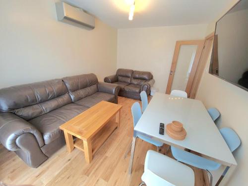 a living room with a leather couch and a table at London Luxury 2 Bedroom Flat Sleeps 8 free parking in East Barnet