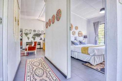a bedroom with a bed and a room with a mirror at The Bedford Manor in Centurion