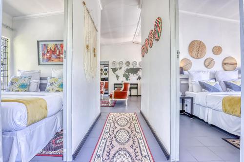a bedroom with two beds and a hallway with a mirror at The Bedford Manor in Centurion