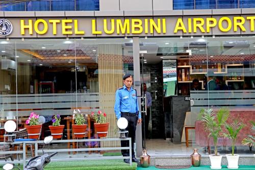 un oficial de policía parado frente a un hotel en Hotel Lumbini Airport, en Katmandú
