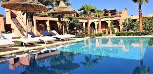 a swimming pool in front of a house at Jenny Lynn in Marrakech