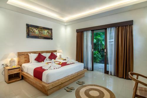 a bedroom with a bed and a large window at d'kamala in Ubud