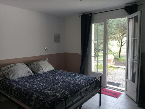 a bedroom with a bed and a sliding glass door at Berbi Rosse in Oletta