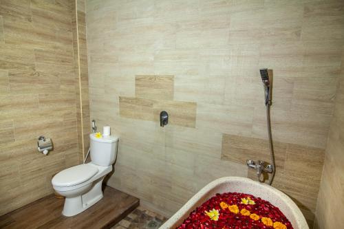 a bathroom with a toilet and a bath tub at d'kamala by Prasi in Ubud