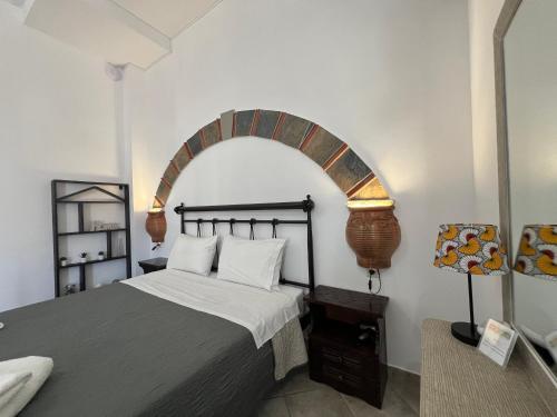 1 dormitorio con 1 cama con arco encima en Xanthi Apartments, en Sivota