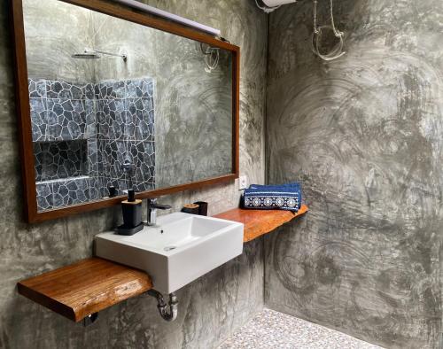 ein Bad mit einem Waschbecken und einem Spiegel in der Unterkunft SeaGate Bungalows in Sabang