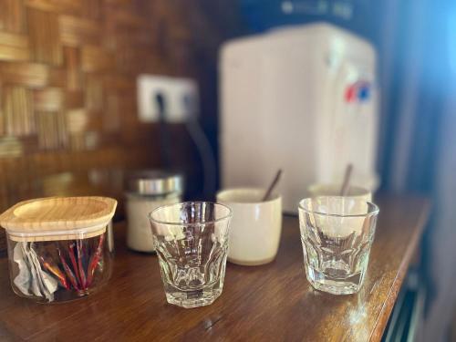 three glasses sitting on top of a wooden table at SeaGate Bungalows in Sabong