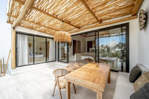 a living room with a wooden table and chairs at Villa Rosado Canggu in Tumbak Bayuh