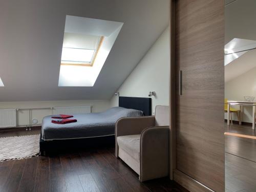 a bedroom with a bed and a couch and a window at Apartments near Noblessner in Tallinn