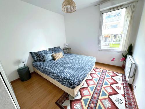 a bedroom with a bed and a rug at Le jardin du stade by UTA HOUSE in Saint-Denis