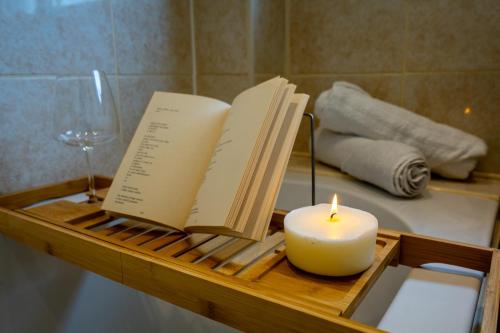 Una vela y dos libros en un estante en un baño en Warm Home for Your Ideal Retreat en Birmingham