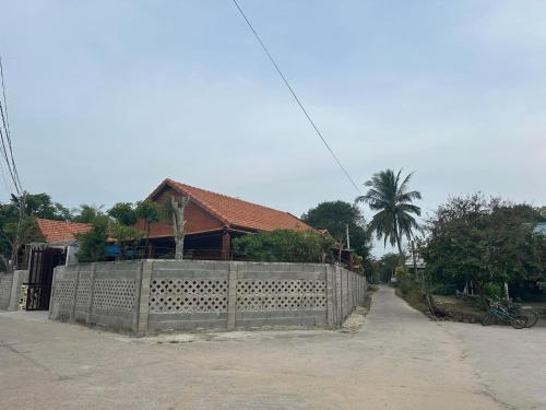 a fence in front of a house with a building at Homestay Bằng Lăng Tím - Bình Thuận in Hàm Tân