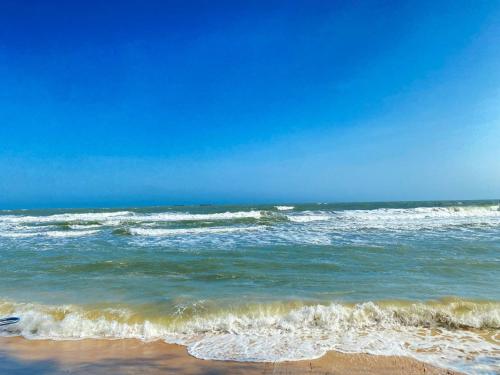 a view of the ocean with waves on the beach at Homestay Bằng Lăng Tím - Bình Thuận in Hàm Tân